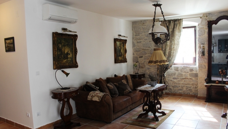 Wohnzimmer in einem Haus in Strp, Montenegro: Vintage-Möbel, Steinmauerwerk, antike Details und ein gemütliches Interieur.
