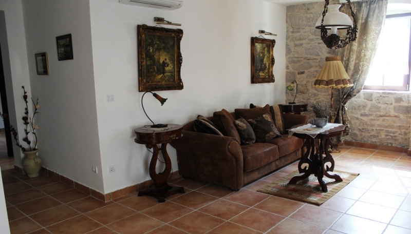 Wohnzimmer in einem Haus in Strp, Montenegro: klassische Möbel, Steinverkleidung, gemütliches Interieur mit antiken Details.
