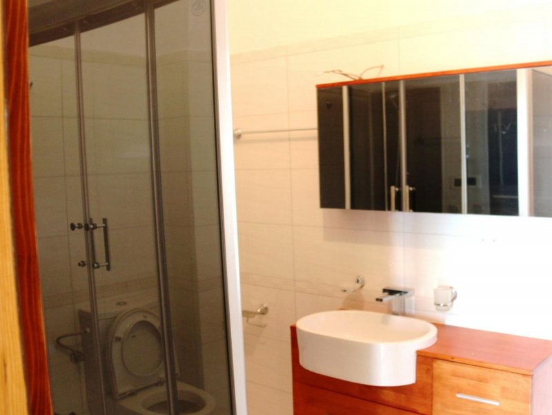Şuşani, Karadağ’daki evde duş kabinli ve lavabo altı dolaplı modern banyo.