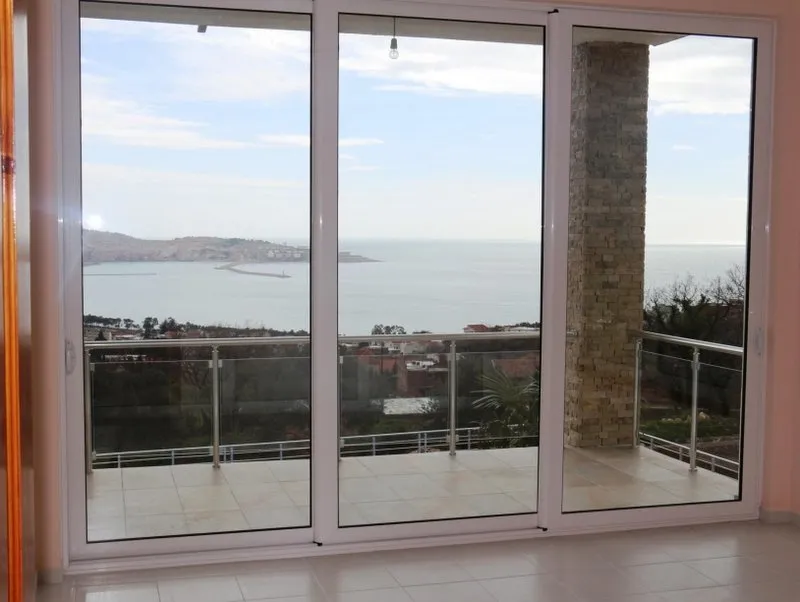 Panoramafenster im Wohnzimmer eines Hauses in Shushan, Montenegro, mit Zugang zur Terrasse und Blick auf das Meer und die Berge.