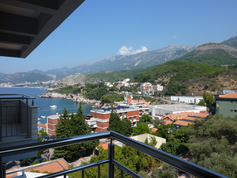 Pogled sa balkona stana u Pržnu, Crna Gora: panorama Jadranskog mora, planina i turističke izgradnje sa zelenilom.