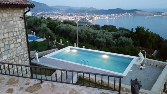 Karadağ, Šušanj'da villa: aydınlatmalı açık yüzme havuzu, taş kaplamalı cephe ve panoramik deniz manzarası.