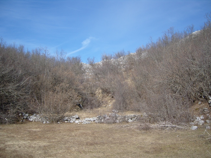 Land plot in Cetinje, Montenegro: mountainous landscape with rocky soil, shrubs, and stone masonry.