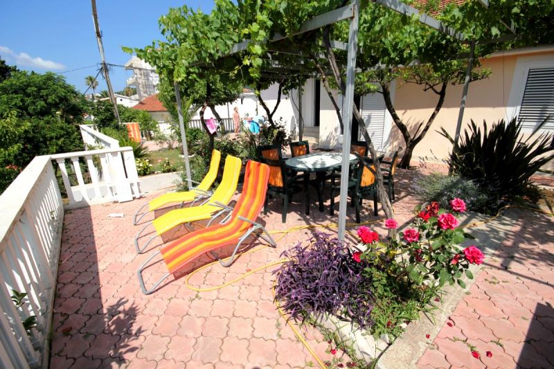 Terrasse confortable avec chaises longues et coin repas sous une vigne, à la maison, Đenovići, Monténégro.