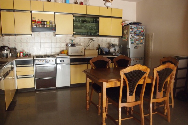 Küche mit gelber Einrichtung und Essbereich im Hotel, Stadt Bečići, Montenegro. Gemütliches Interieur zum Entspannen.
