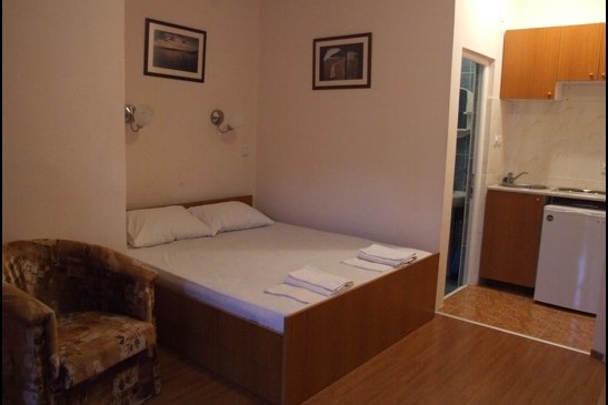 Schlafzimmer im Hotel Bečići, Montenegro: Doppelbett, Sessel, Kochnische und separates Badezimmer.
