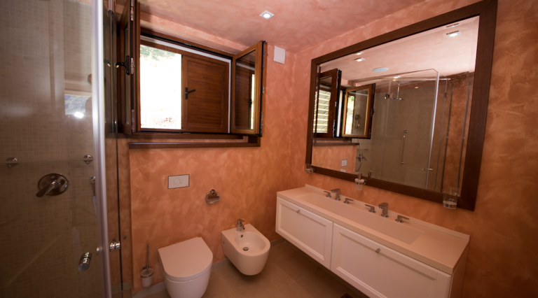 Badezimmer im Haus, Stoliv, Montenegro: moderne Sanitäranlagen, Duschkabine und Wandverkleidung in warmen Tönen.