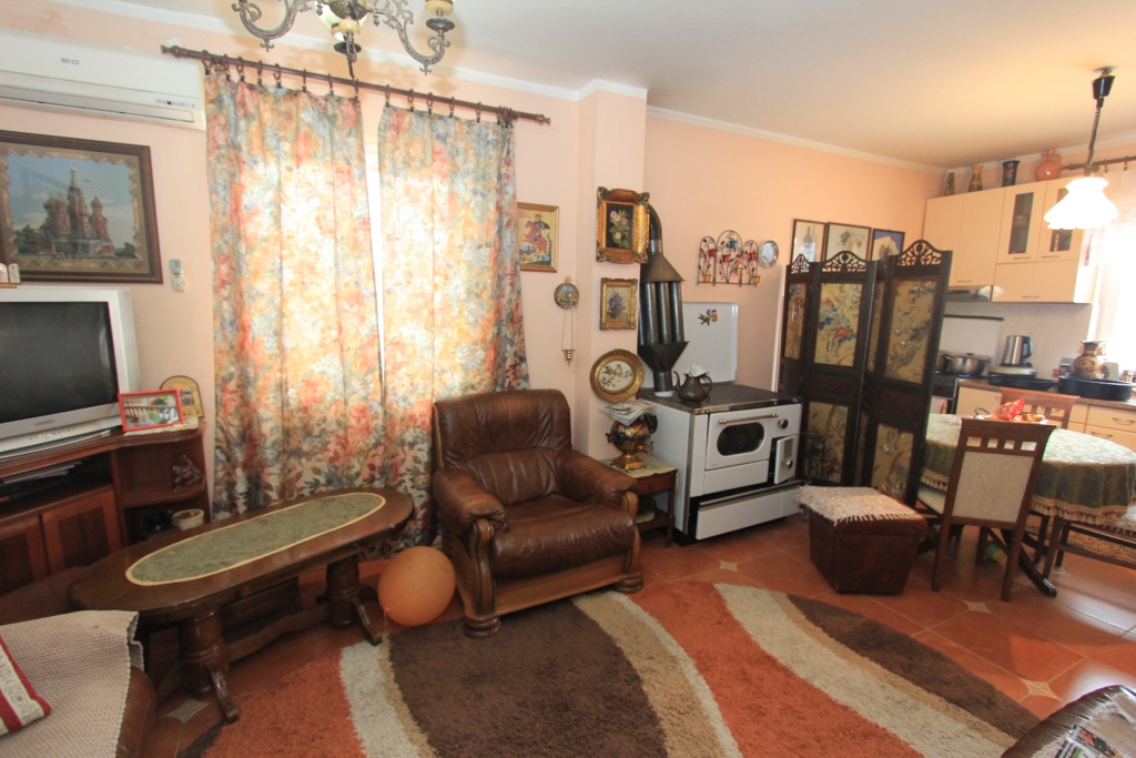Wohnzimmer in einem Haus in Radanovići, Montenegro: Ledersessel, Holzofen, Essbereich und klassisches Interieur.