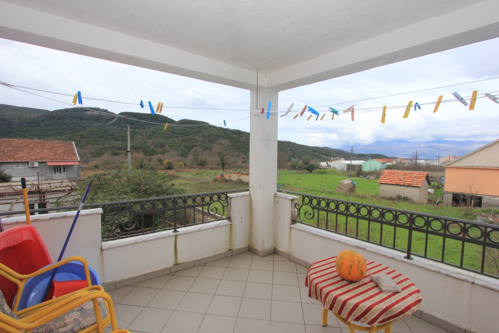 Geräumiger Balkon mit Bergblick in einem Haus, Radanovići, Montenegro: Fliesenboden, schmiedeeisernes Geländer und Tisch.