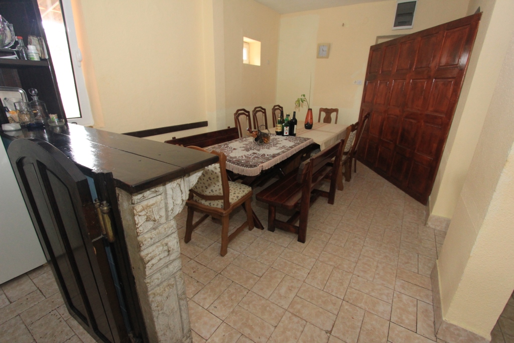 Küche mit Essbereich und Holzmöbeln sowie Bar in einem Haus, Radanovići, Montenegro. Fliesenboden, klassischer Stil.