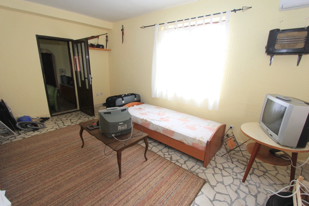Schlafzimmer in einem Haus in Radanovići, Montenegro: Einzelbett, Fernseher, Teppich und Fliesenboden im Innenraum.