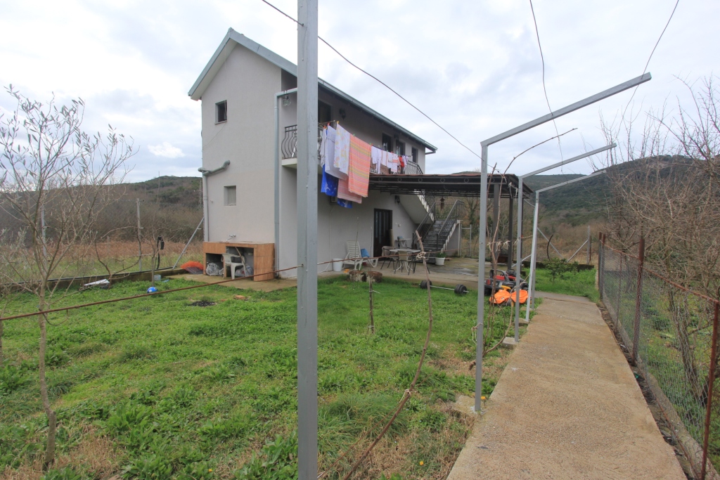 Zweistöckiges Haus mit Grundstück und Sommerküche in Radanovici, Montenegro: Blick auf die Fassade, den Garten und die überdachte Terrasse.