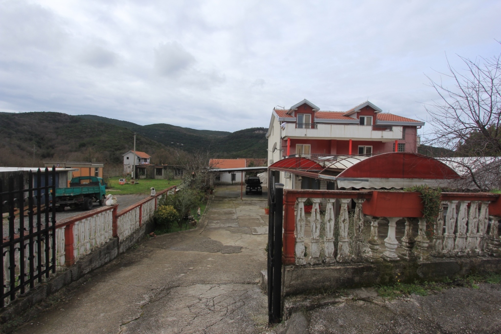 Privathaus mit Grundstück und Parkplatz in Radanovići, Montenegro: Blick auf das Grundstück mit Bergen im Hintergrund.