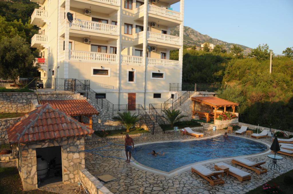 Willa w Markovici, Czarnogóra: odkryty basen z leżakami, kamienny taras i widok na góry przy wielopiętrowym domu.
