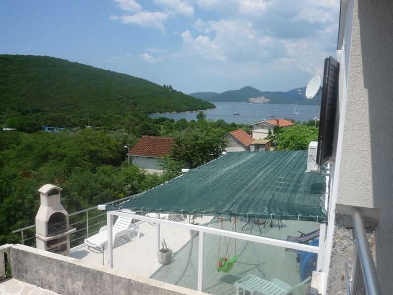 Terrasse der Villa in Bigovo, Montenegro: Meerblick, Liegestühle, Gartenschaukel und Steingrill auf dem Balkon.