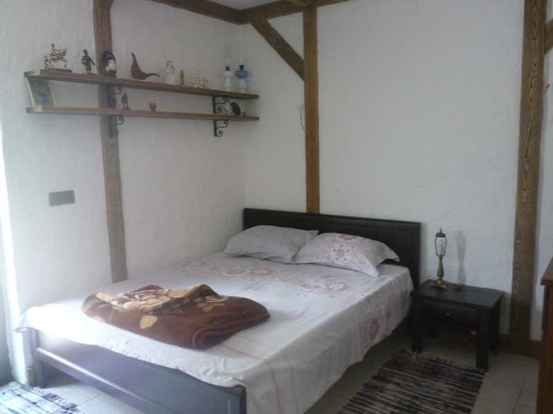 Schlafzimmer mit Doppelbett und Holzbalken in einer Villa in Bigovo, Montenegro: Interieur im rustikalen Stil.