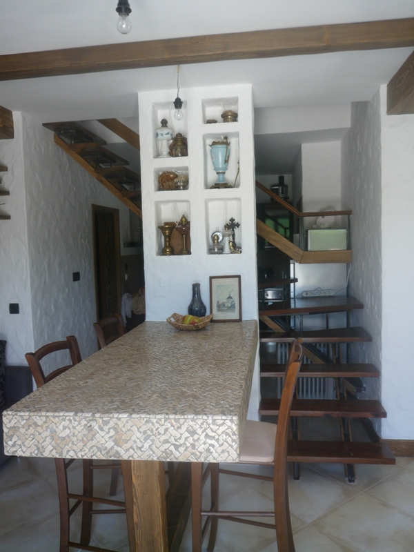 Kücheninterieur in einer Villa in Bigovo, Montenegro: Bartheke, Holztreppe und dekorative Wandnischen.