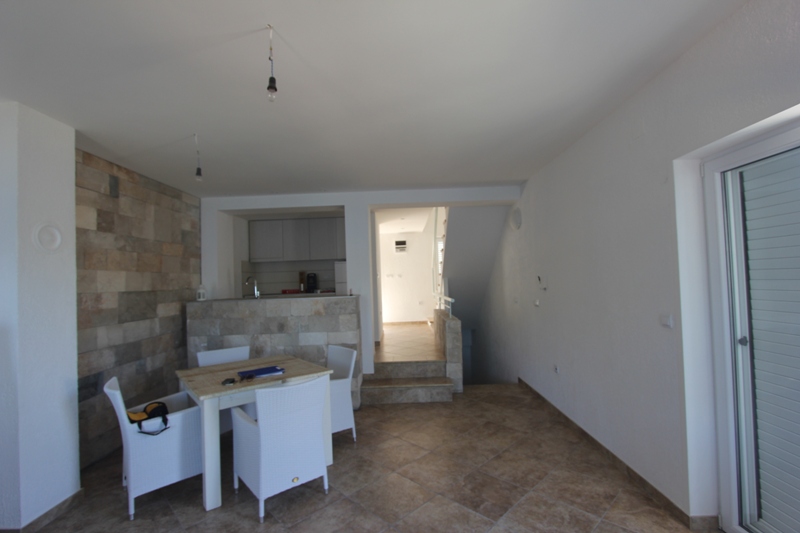 Wohnzimmer mit Essbereich und Steinverkleidung in einem Haus auf der Halbinsel Luštica, Montenegro: Innenraum mit Zugang zur Terrasse