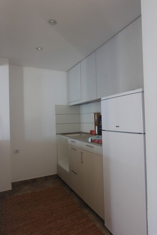 Moderne helle Küche mit weißem Kühlschrank in einem Haus auf der Halbinsel Luštica, Montenegro.