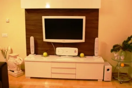 Modernes Wohnzimmer mit TV-Bereich in einem Haus in Igalo, Montenegro: weißes Lowboard, Fernseher und Soundsystem.