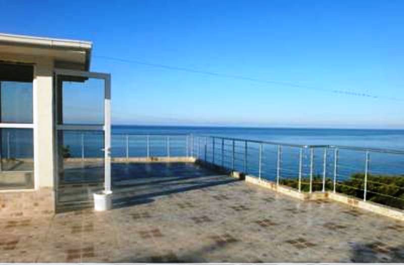 Spacious terrace with panoramic sea views at a mini-hotel, Šušanj, Montenegro: tiled floor and metal railing.