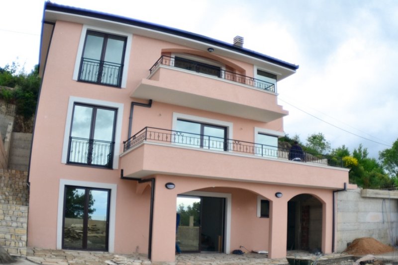 Dreistöckiges pfirsichfarbenes Haus mit Balkonen und Terrasse in Šušanj, Montenegro. Außenansicht der Fassade des Gebäudes.