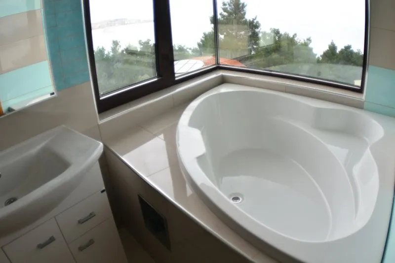 Badezimmer mit Eckbadewanne und Panoramablick auf das Meer in einem Haus, Šušanj, Montenegro.