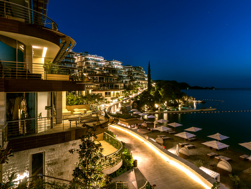 Karadağ, Bečići’deki Dukley Gardens lüks konut kompleksinin terasları ve özel plajıyla akşam manzarası.
