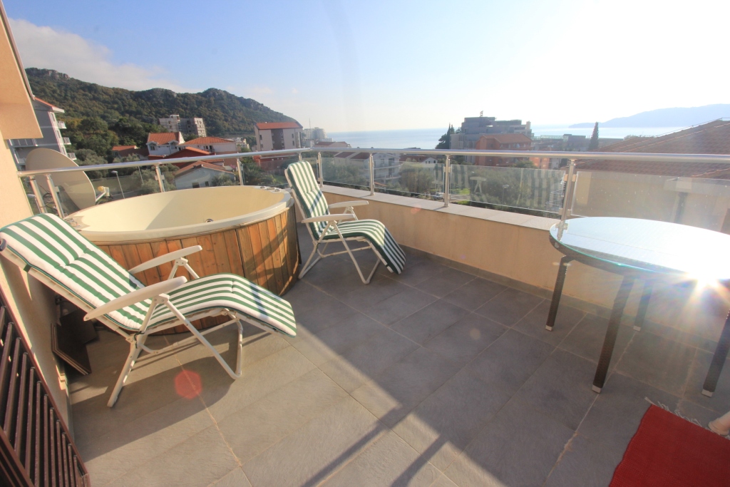 Terrasse der Wohnung in Rafailovici, Montenegro: Whirlpool, Sonnenliegen und Panoramablick auf das Meer und die Berge.