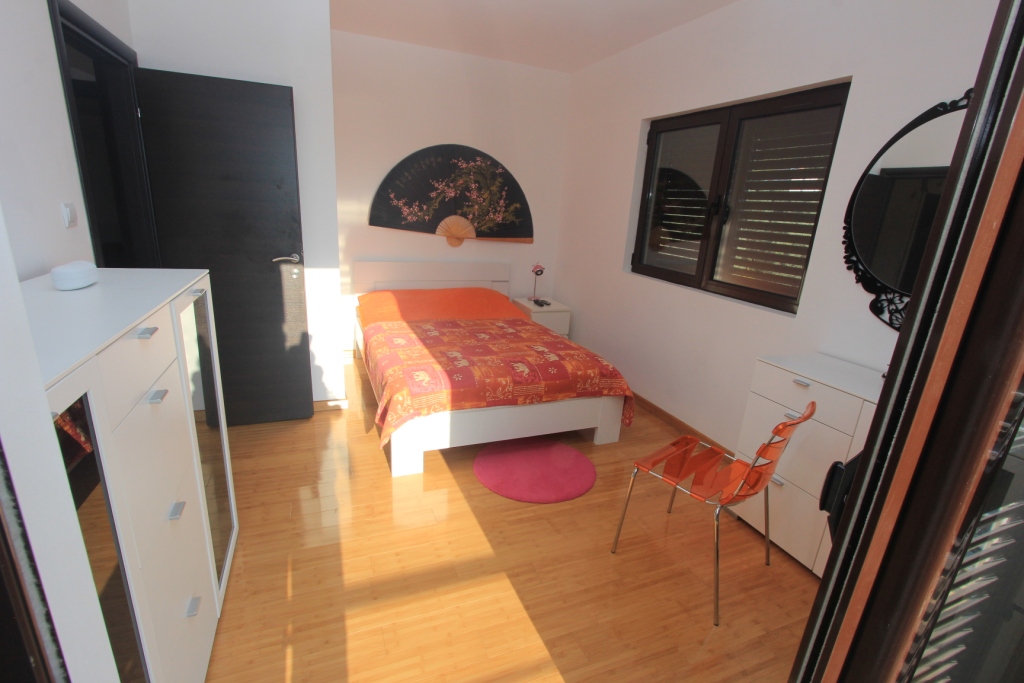 Helles Schlafzimmer in einer Wohnung in Rafailovici, Montenegro: Doppelbett, weiße Möbel, Parkett und Dekor im orientalischen Stil