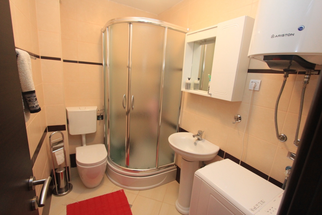 Badezimmer in einer Wohnung in Rafailovići, Montenegro: Duschkabine, Waschbecken, Toilette und Ariston-Boiler.