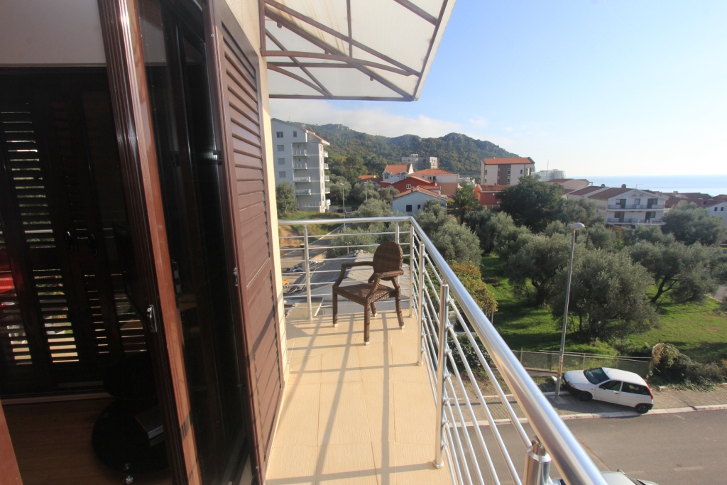 Balkon mit Rattanmöbeln und Blick auf die Berge und das Meer in einer Wohnung in Rafailovići, Montenegro.