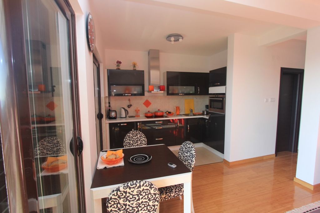 Moderne Küche mit schwarzer Einbauküche und Essbereich in einer Wohnung, Rafailovići, Montenegro.