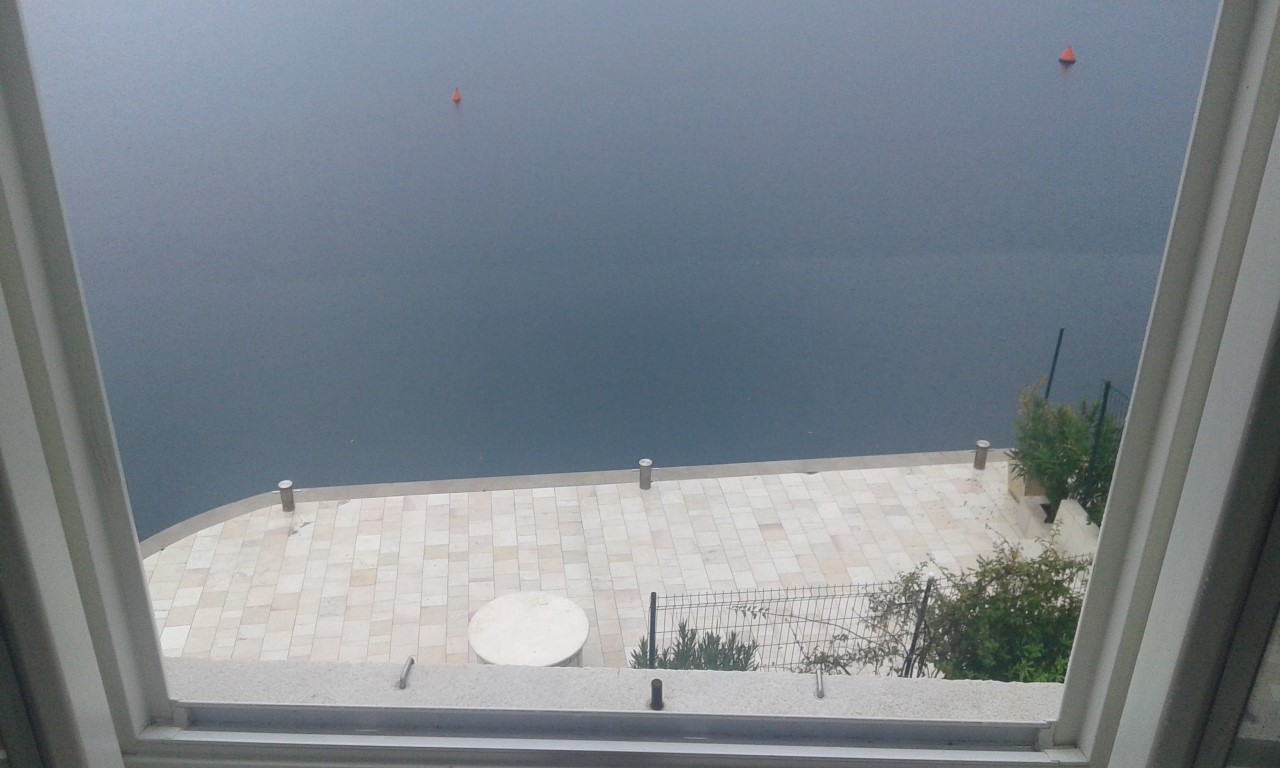 Pogled iz prozora na privatni mol i more u Perastu, Crna Gora: terasa sa kamenim popločanjem uz vodu u vili br. 707.