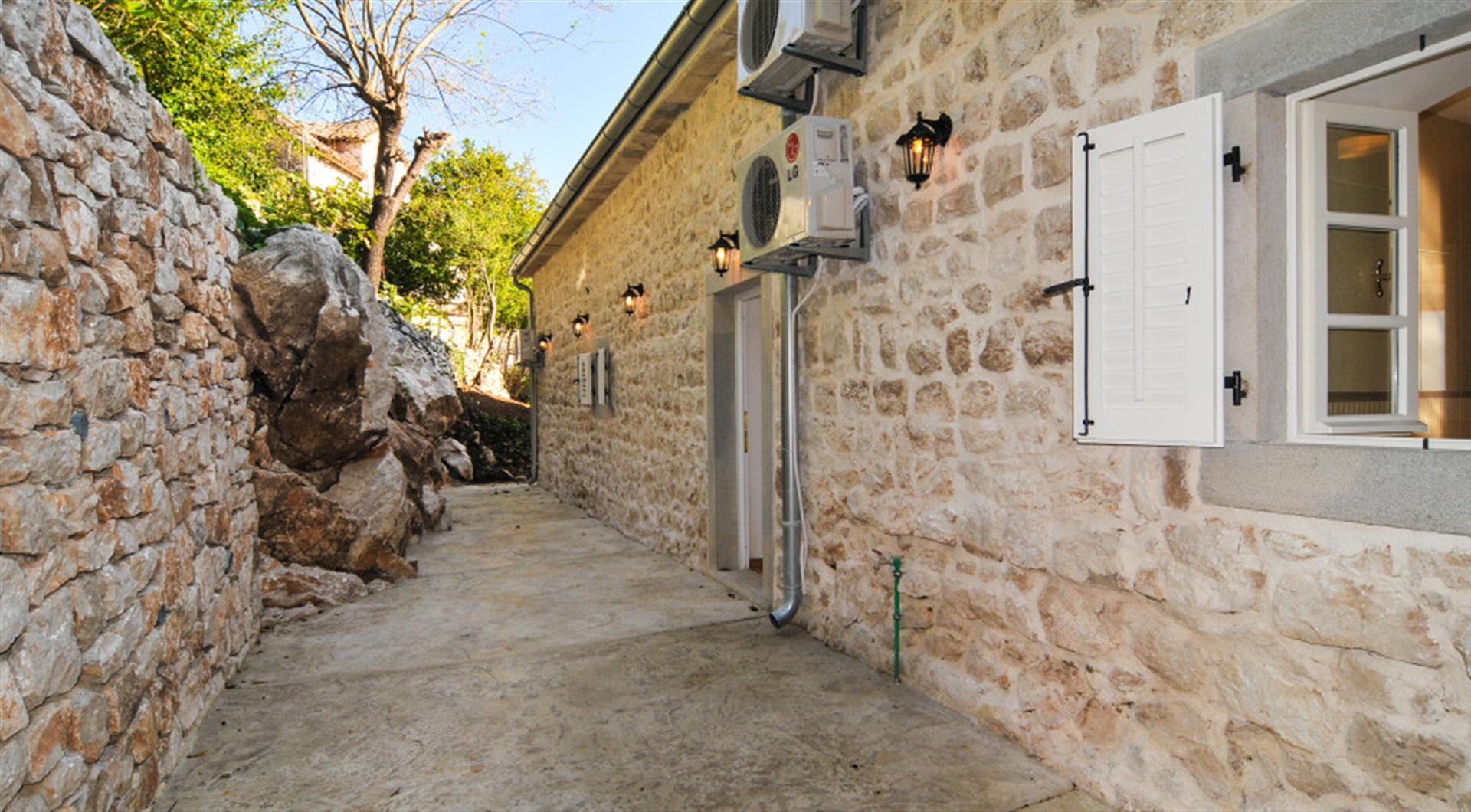 Karadağ, Dražin Vrt’te teraslı doğal taş villa cephesi: taş duvarlar ve peyzaj manzarası.