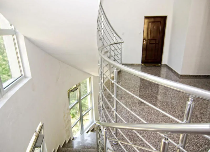Treppe mit Metallgeländer und glänzendem Boden
