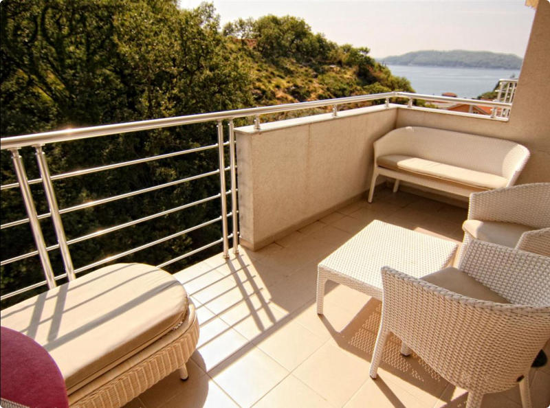 Becici, Karadağ’daki dairede deniz manzaralı, hasır mobilyalı уютный balkon. Modern metal korkuluk.