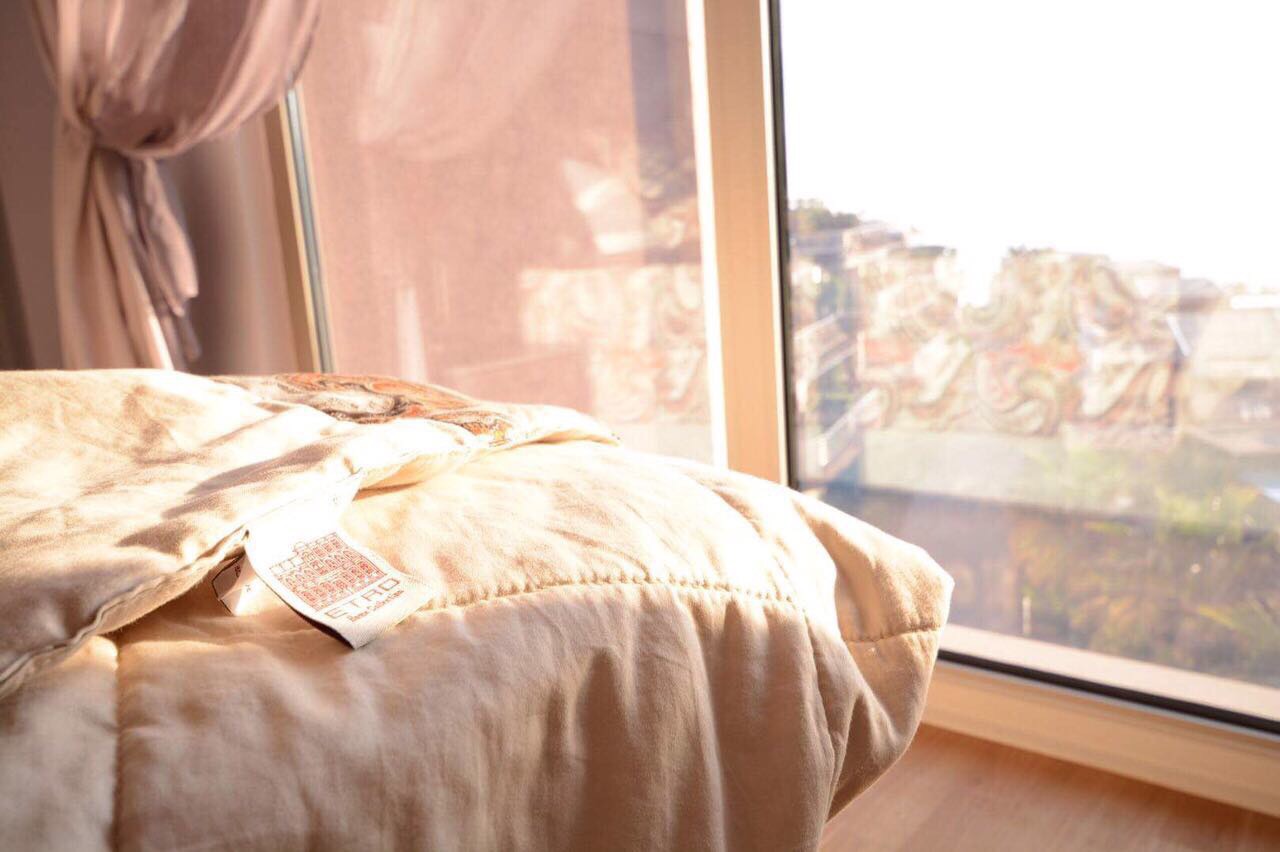 Chambre cosy avec baie vitrée panoramique et vue sur la mer dans un appartement à Bečići, Monténégro, avec du linge de qualité Etro.