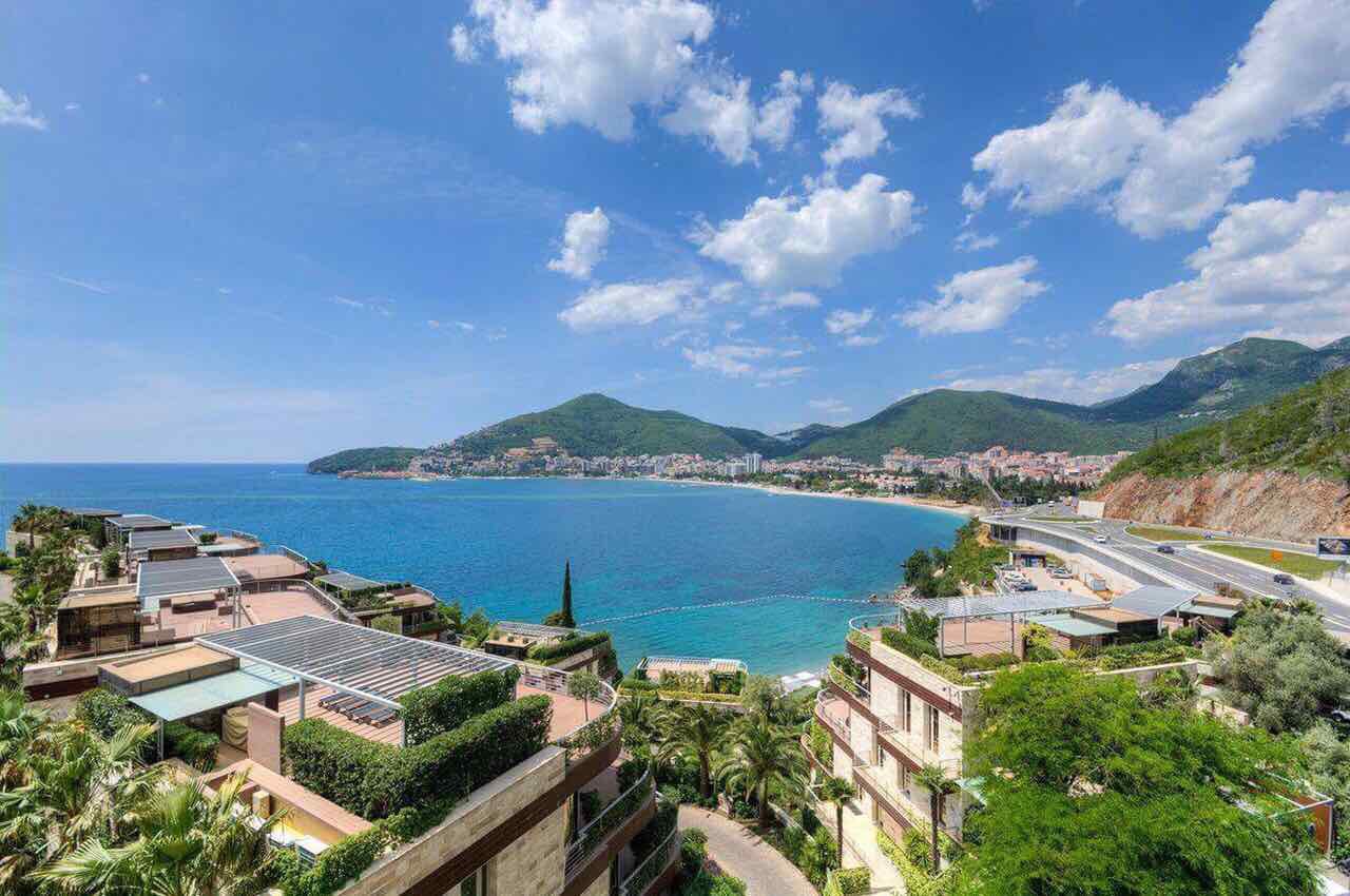 Vue sur un complexe résidentiel moderne avec terrasses et vue panoramique sur la mer et la plage à Bečići, Monténégro.