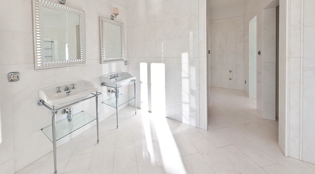 Helles Badezimmer mit zwei Waschbecken und Marmorverkleidung in einer Villa in Dobrota, Montenegro.
