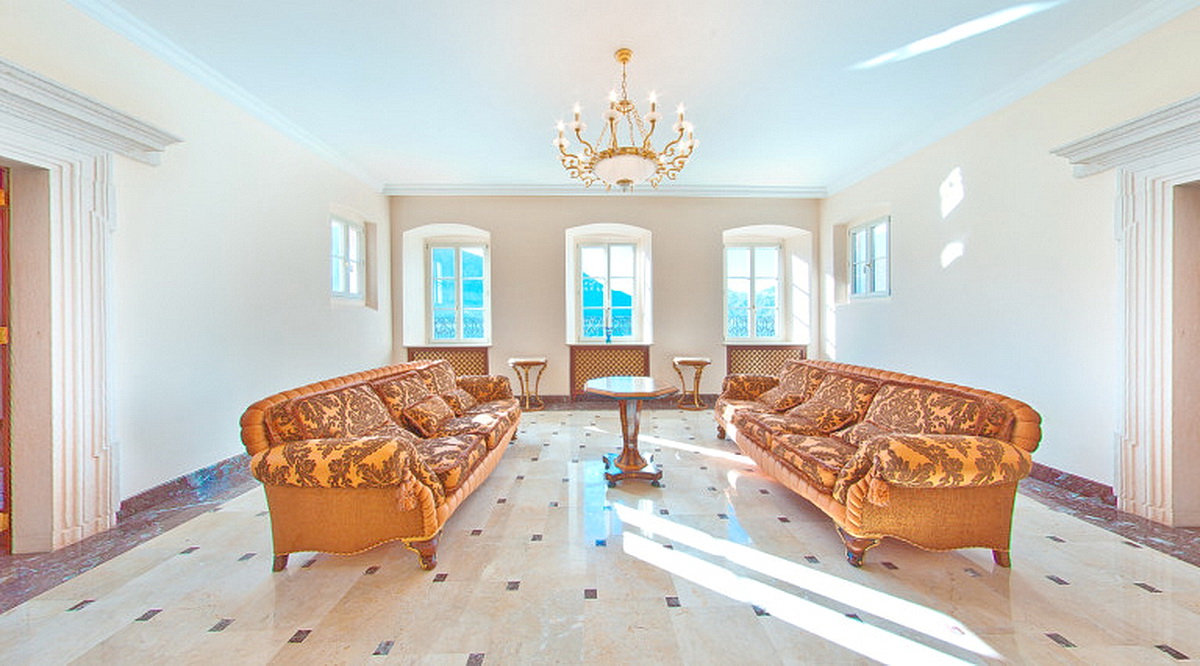 Luxuriöses Wohnzimmer mit klassischer Einrichtung und Marmorboden in einer Villa in Dobrota, Montenegro. Blick auf die Berge aus den Fenstern.