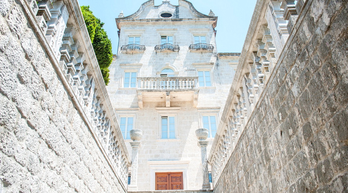 Historische Steinvilla in Dobrota, Montenegro: Fassade mit Balkonen, geschnitzten Geländern und repräsentativer Treppe.