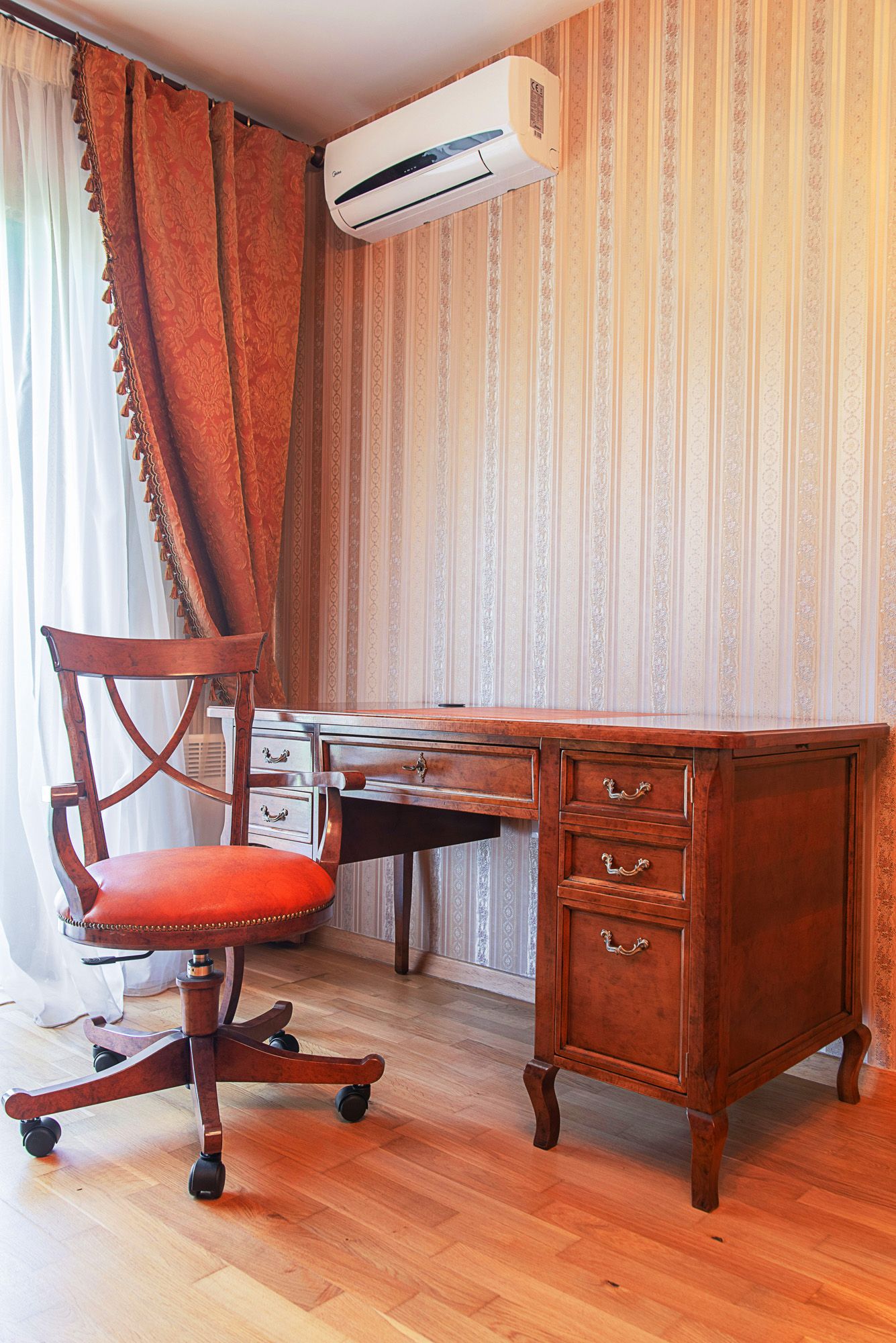 Bureau dans une maison de ville à Lastva, Monténégro : bureau ancien en bois, fauteuil et climatisation dans l’intérieur.