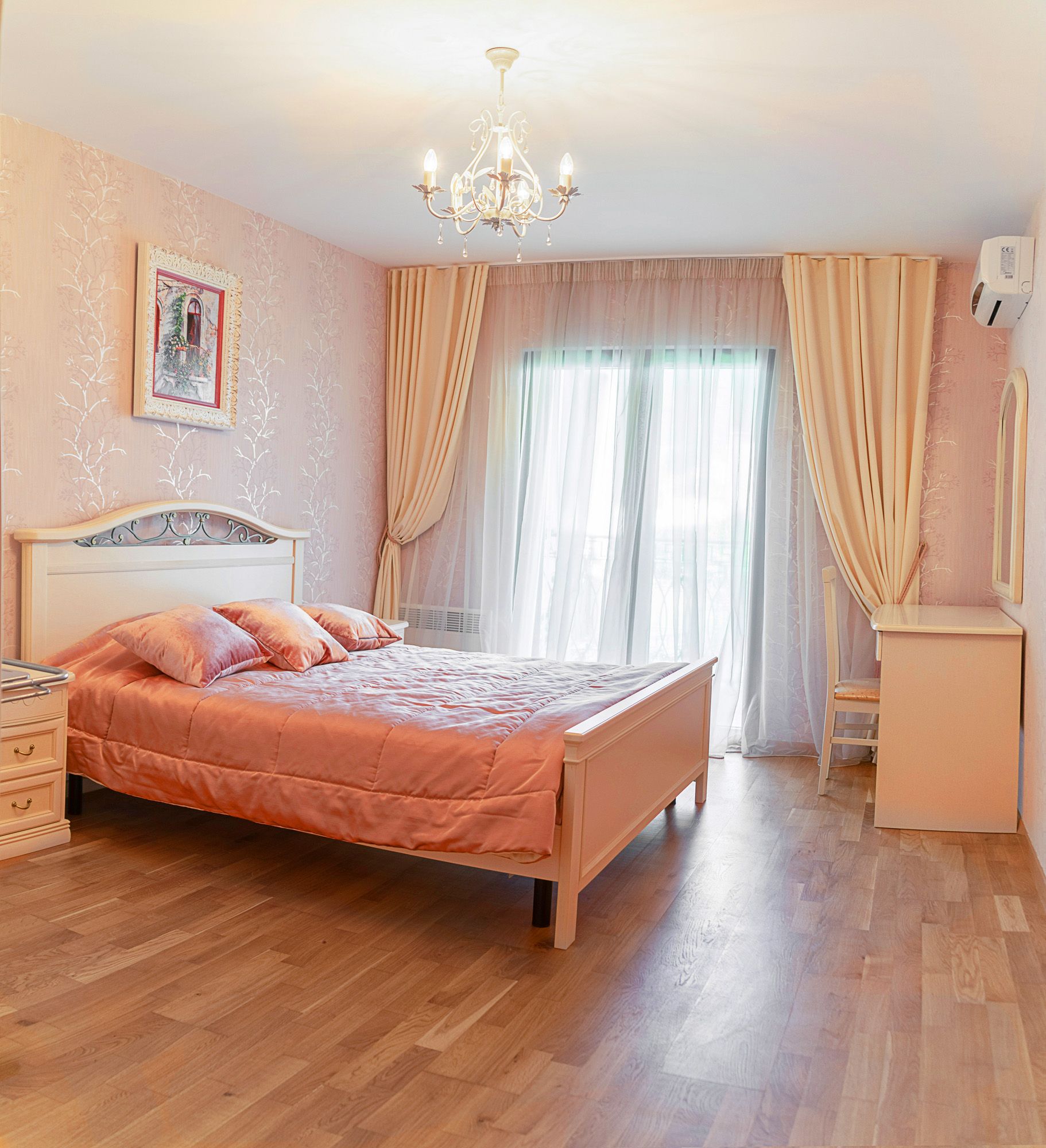 Chambre confortable avec lit double dans une maison de ville, Lastva, Monténégro : mobilier clair, parquet et accès au balcon.