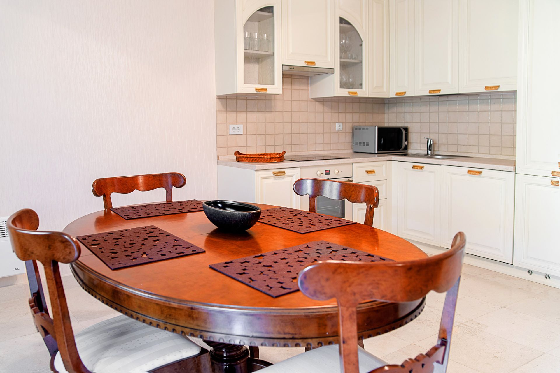 Cuisine avec meubles blancs et table à manger en bois dans une maison de ville, Lastva, Monténégro.