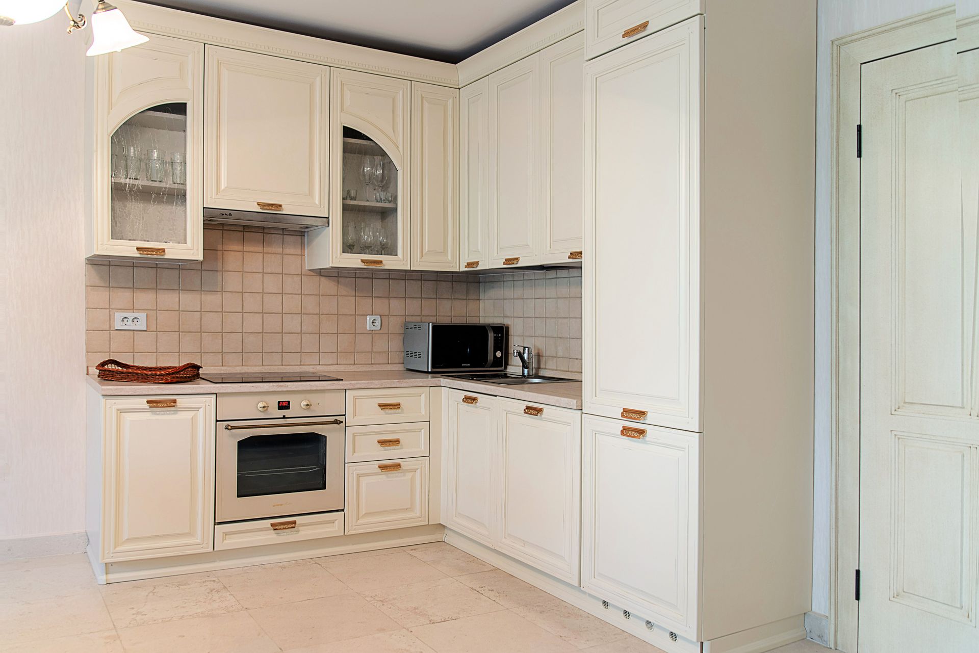 Cuisine classique lumineuse avec électroménager dans une maison de ville, Lastva, Monténégro : meubles intégrés et crédence carrelée.