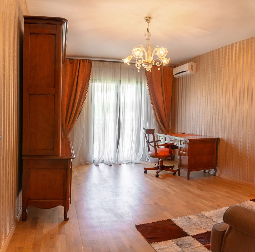 Bureau classique dans une maison de ville à Lastva, Monténégro : mobilier en bois, papier peint à rayures et accès à la terrasse.