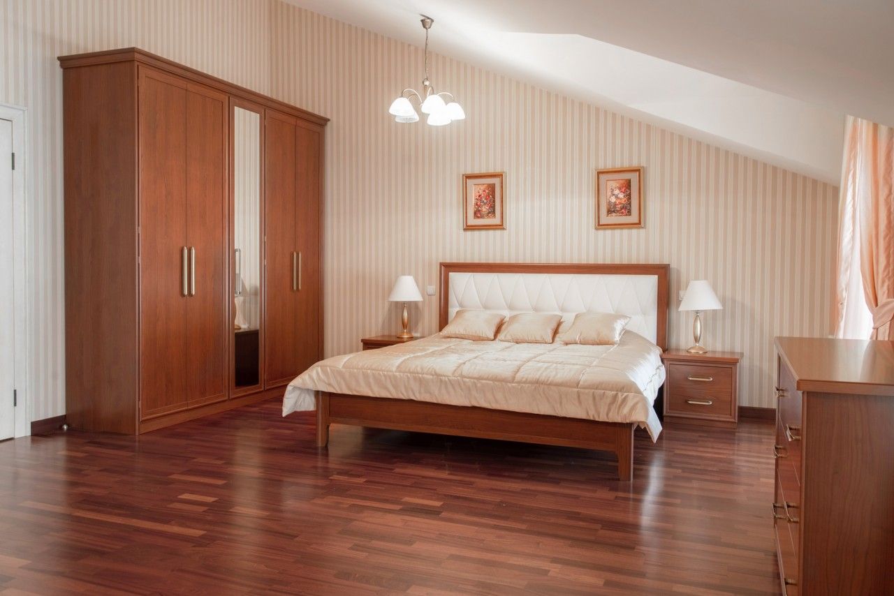Chambre confortable dans une maison de ville à Lastva, Monténégro : lit double, armoire en bois et parquet à l’intérieur.