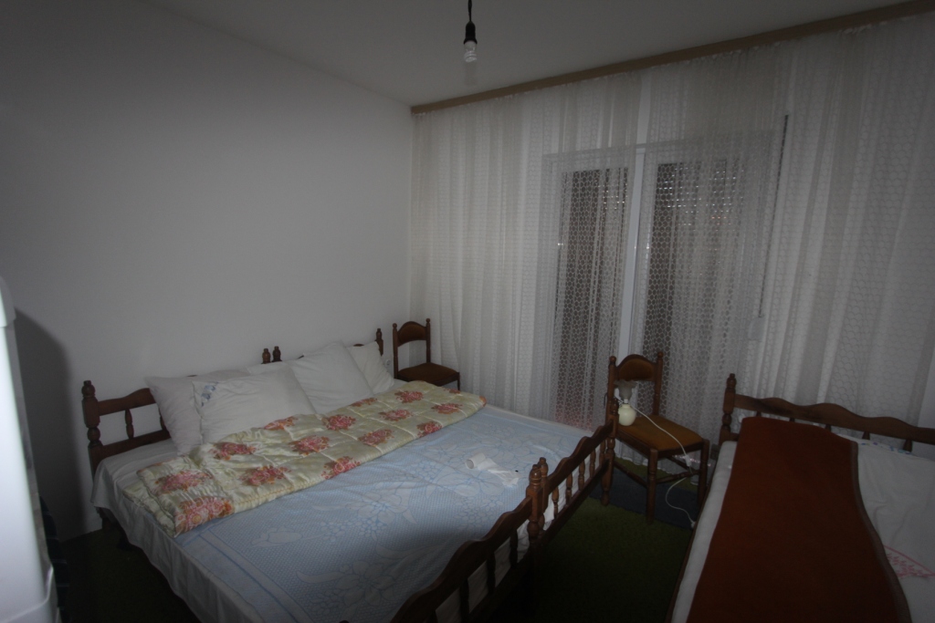 Schlafzimmer mit Holzbetten und Zugang zum Balkon im Haus, Stadt Radovići, Montenegro.