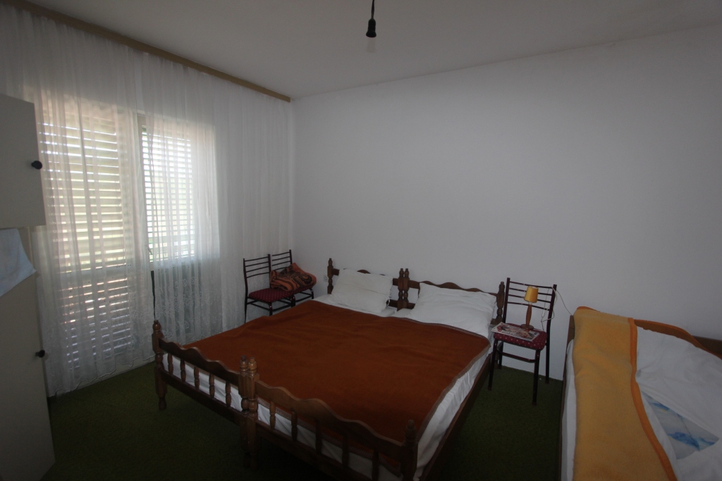Schlafzimmer mit Doppelbett in einem Haus in Radovići, Montenegro: heller Raum mit Fenster und klassischer Einrichtung.